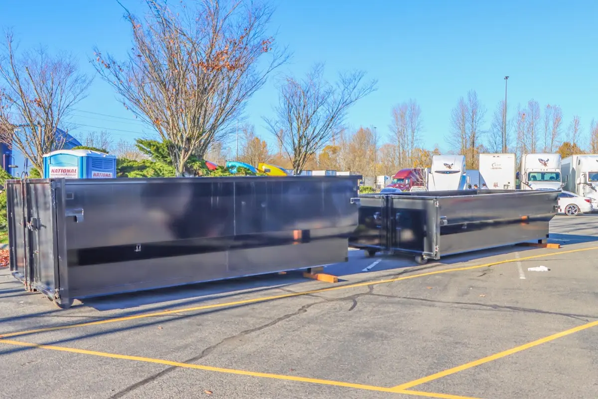 Professional dumpster rental service with roll-off container on residential driveway in Mena